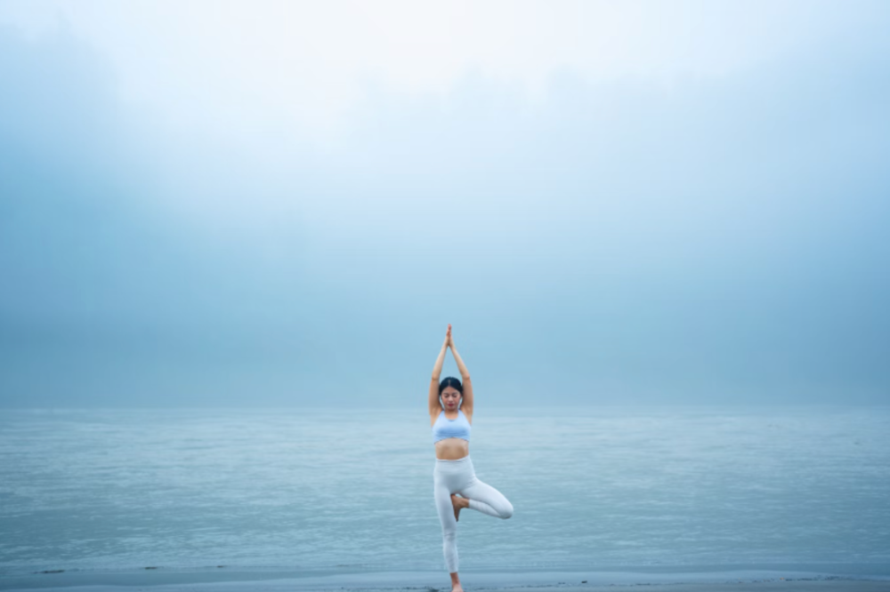 An image of a woman doing yoga in front of the sea