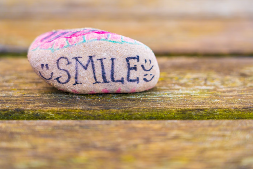 A rock with 'smile' written on it