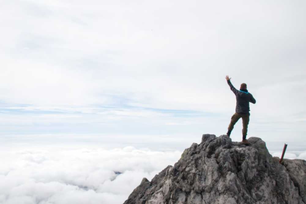 An image of a man at the top of a mountain