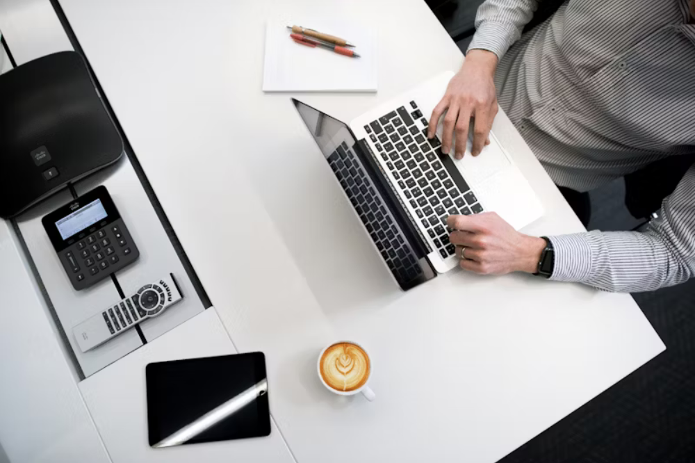 An image of a man on his computer with a cup of coffee