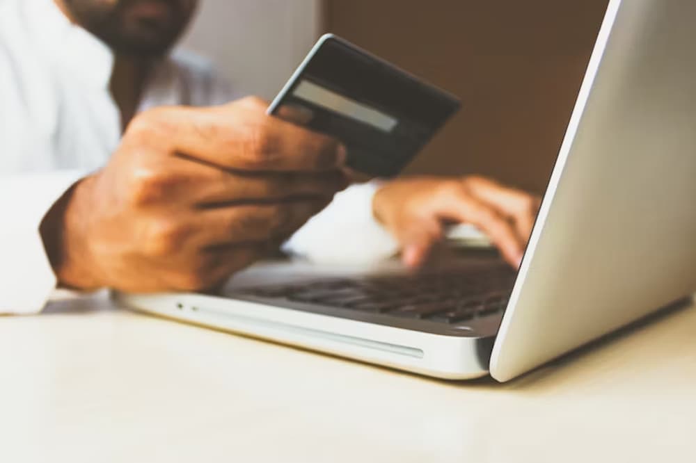 A picture of a man about to make a payment with his bank card